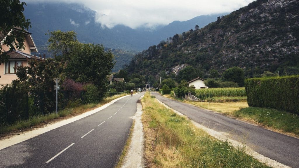 Eine malerische Landstraße in Frankreich, die sich durch atemberaubende Berglandschaften schlängelt, perfekt für ein unvergessliches Roadtrip-Abenteuer.